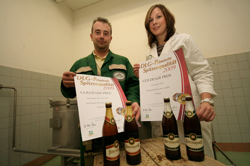 www.sternquell.de, Brauer Mirko Werner und Katja Ziegenhals von der Qualitätssicherung zeigen im Sudhaus der Sternquell-Brauerei stolz die Urkunden der goldenen DLG-Prämierung. 